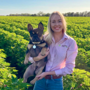 Cotton marketer Jess Strauch pictured holding her dog standing in a cotton paddock.