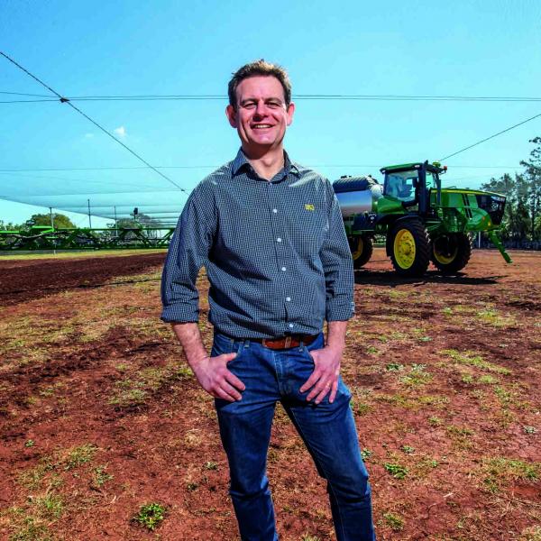 Prof. Craig Baillie standing in front of John Deere tractor